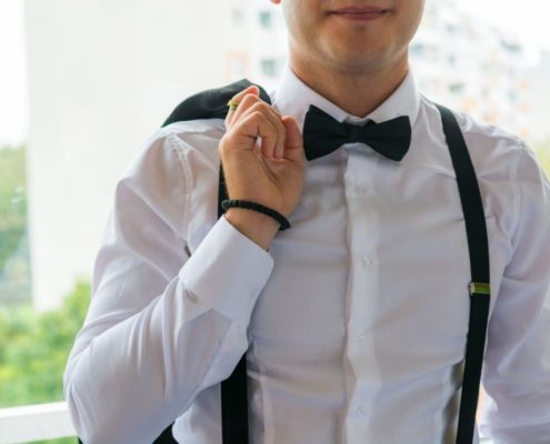 Man modeling men's black suspenders and black bow tie
