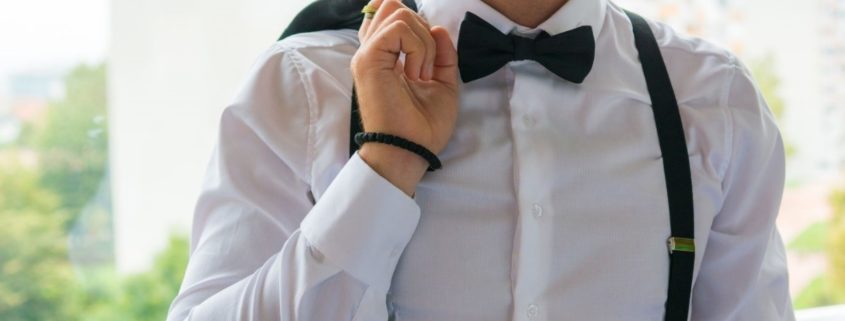 Man modeling men's black suspenders and black bow tie
