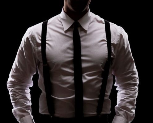 Model wearing black suspenders and tie