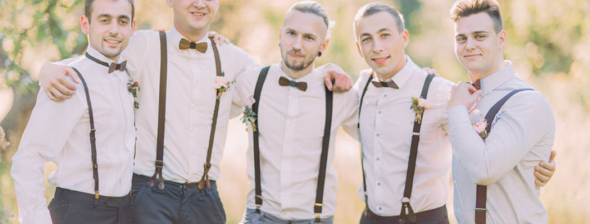 Groomsmen wearing black suspenders and black bow ties